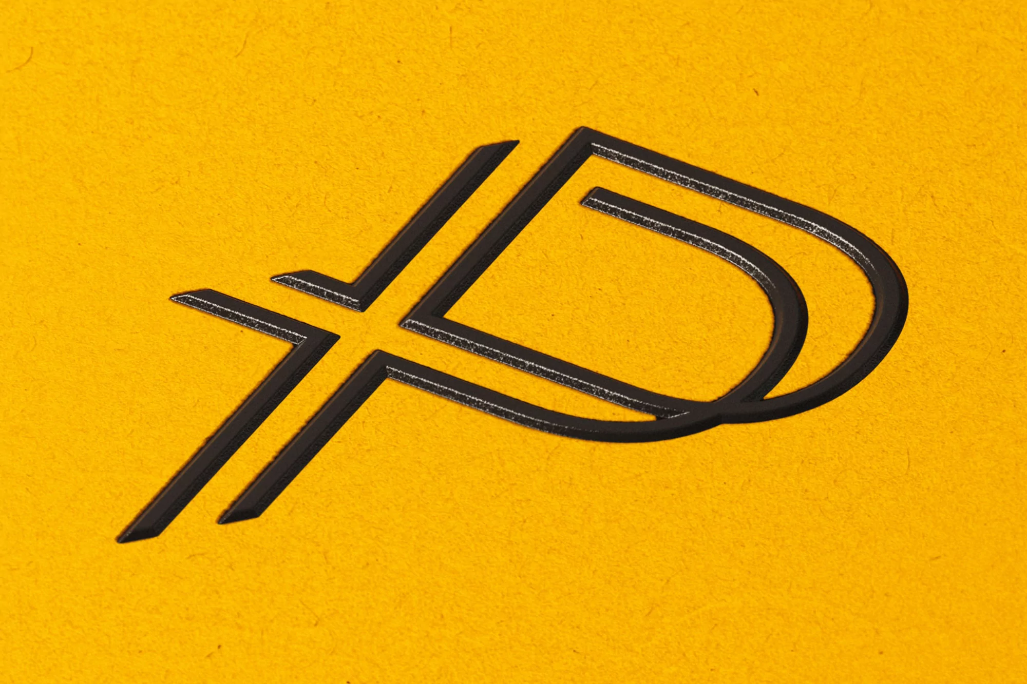 Abstract logo on textured yellow surface featuring interlocking black shapes reminiscent of 'A' and 'P' initials, close-up.