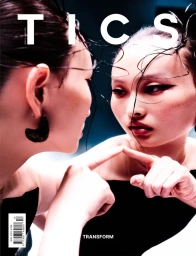 Model touching her own reflection in a mirror, featuring glossy dark hair and dramatic eye makeup for TICS Magazine Issue 13.