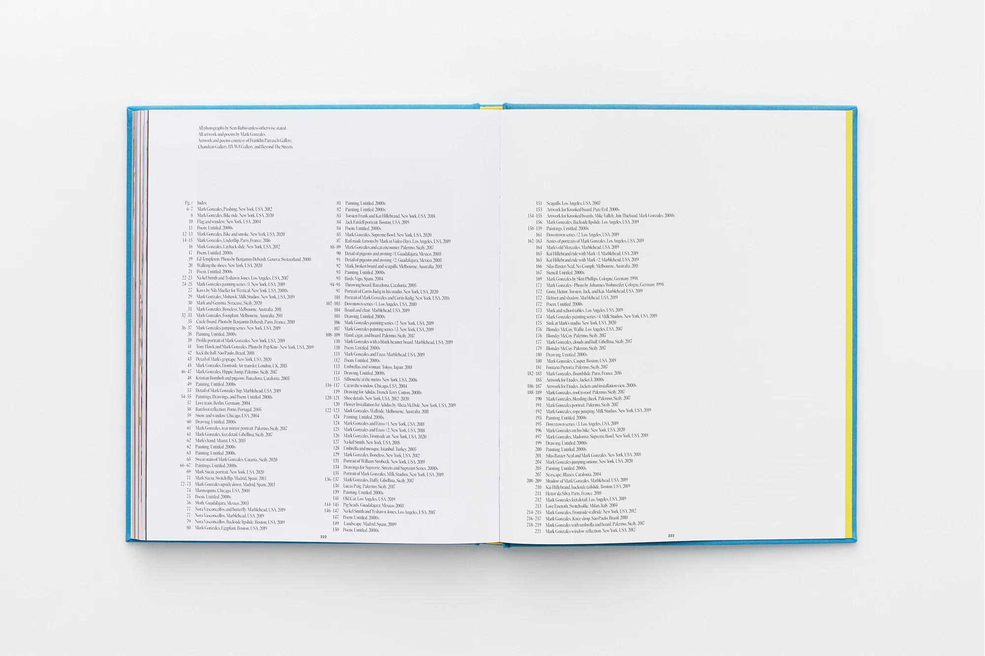 Open book on a white surface, showcasing two pages filled with dense text and a thin, light-blue and yellow binding.
