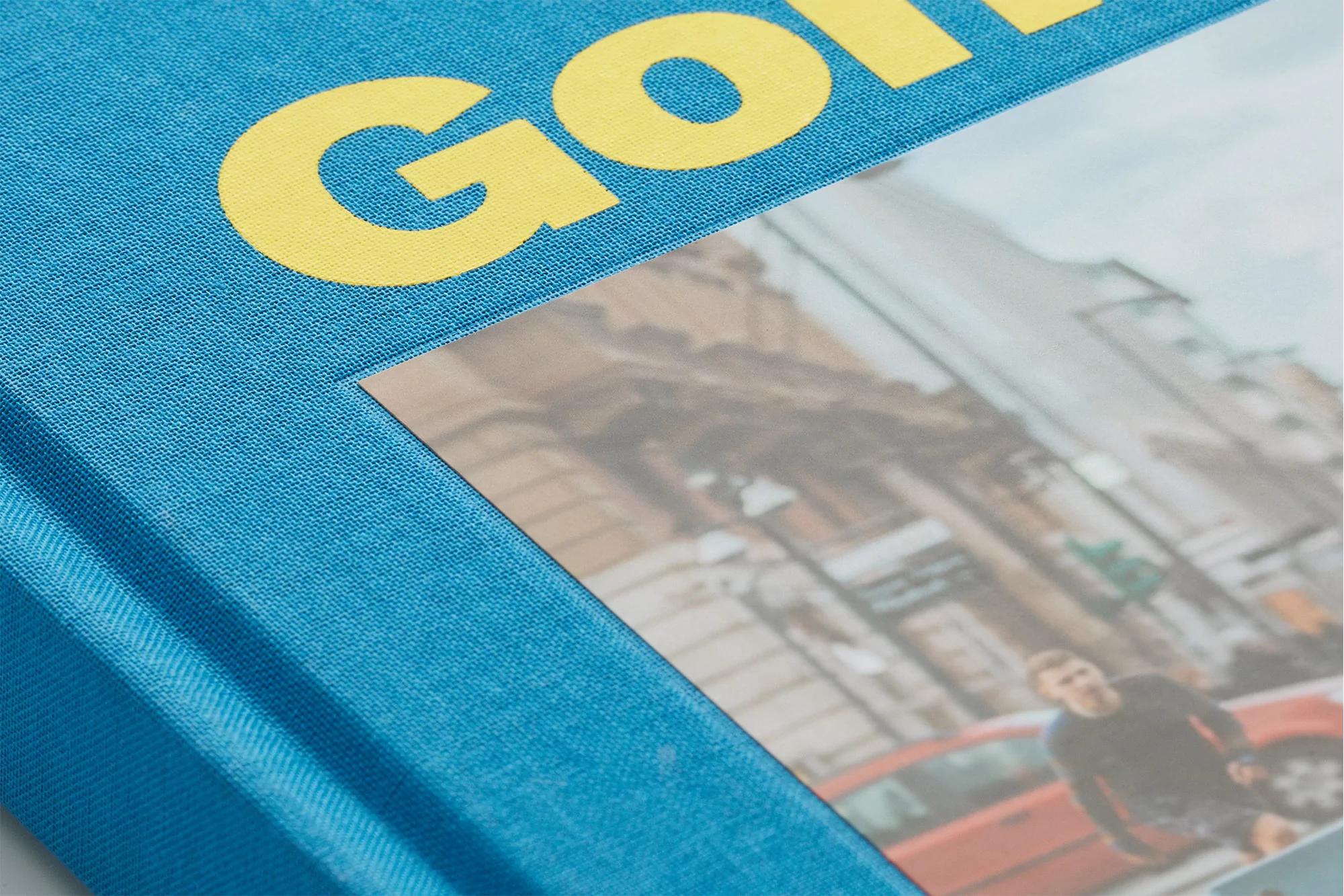 Close-up of a blue fabric book cover with yellow embossed typography for Mark Gonzales by Studio Albin Holmqvist