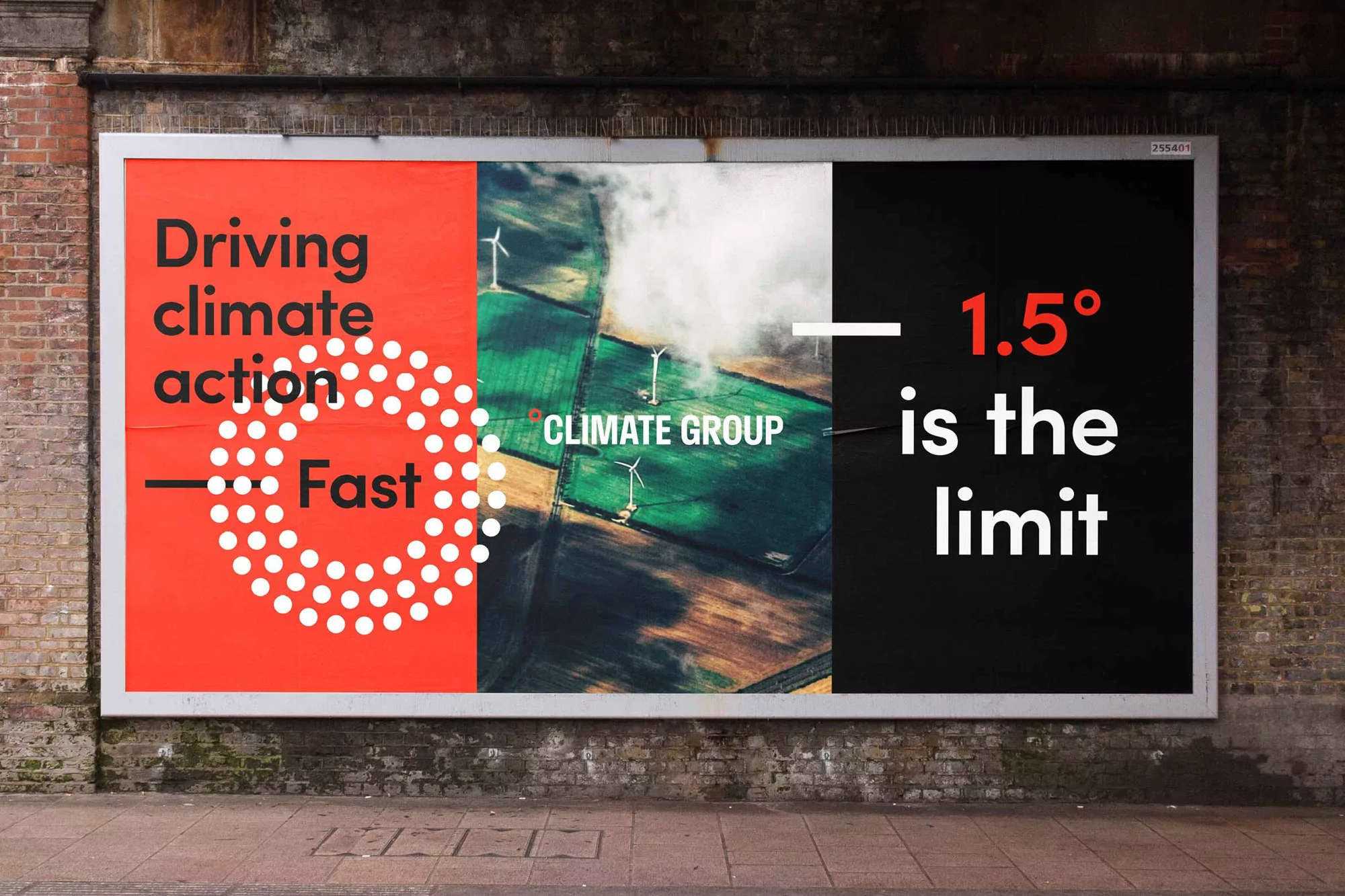 Billboard advertisement promoting climate action with wind turbine imagery, set against a brick wall, showcasing a message for environmental awareness.
