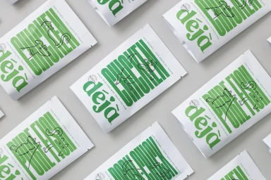 Flat lay of white pet treat pouches featuring bold green typography and line-drawn animal illustrations.