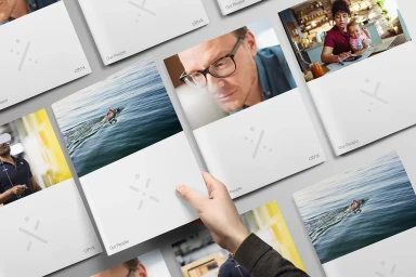 Hand holding a brochure mockup featuring photography for Citrix brand identity project, arranged on a surface