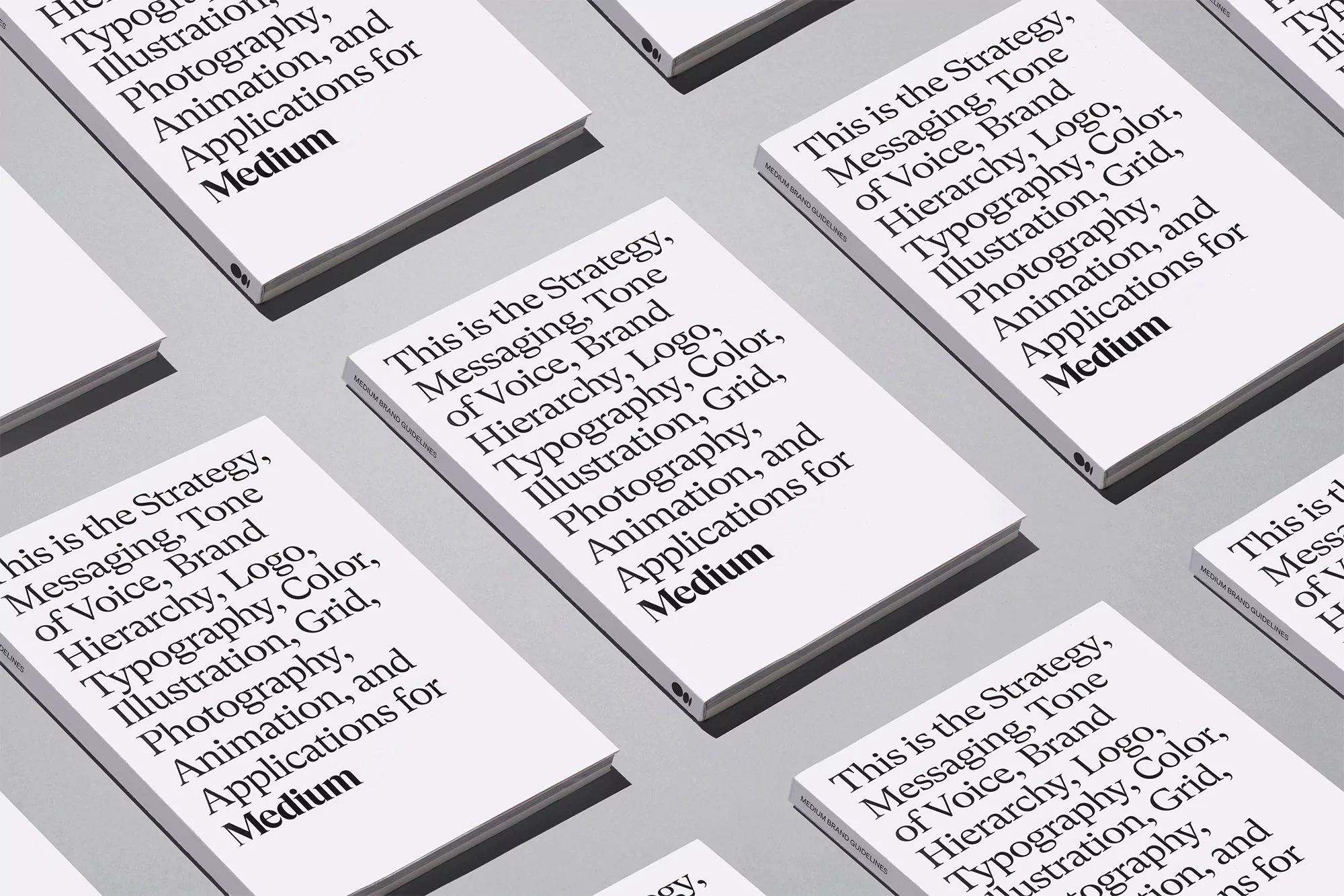 Multiple white books with black text arranged in a pattern on a grey background, featuring the word Medium.