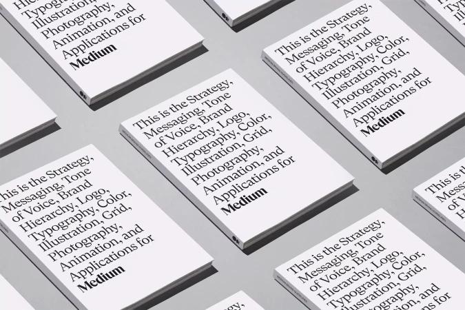 Multiple white books with black text arranged in a pattern on a grey background, featuring the word Medium.