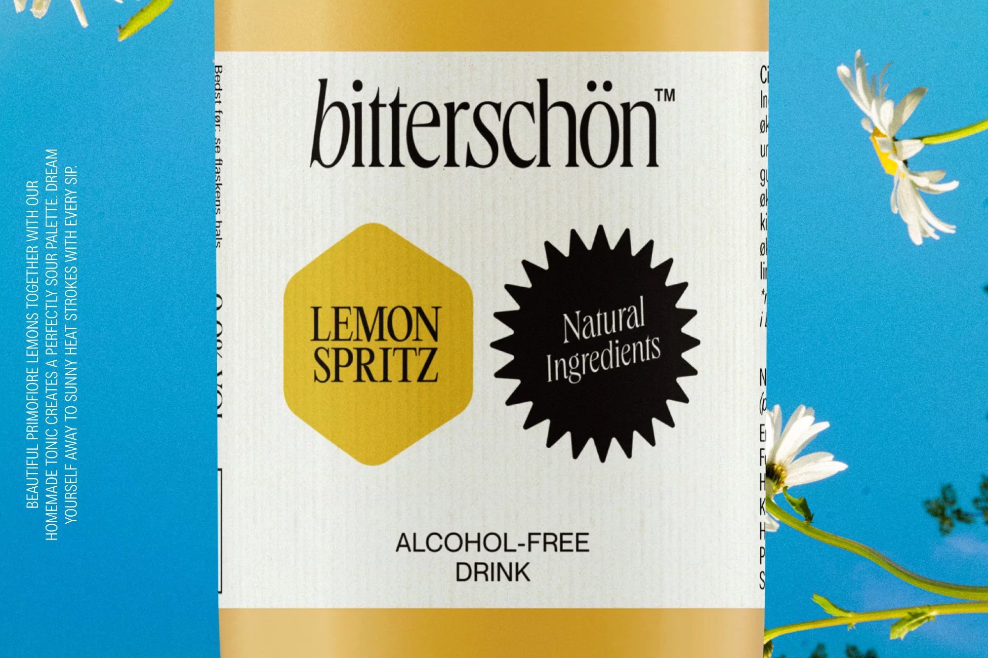 Bitterschön Lemon Spritz bottle label featuring product name, natural ingredients seal, and daisy flowers against a blue sky.