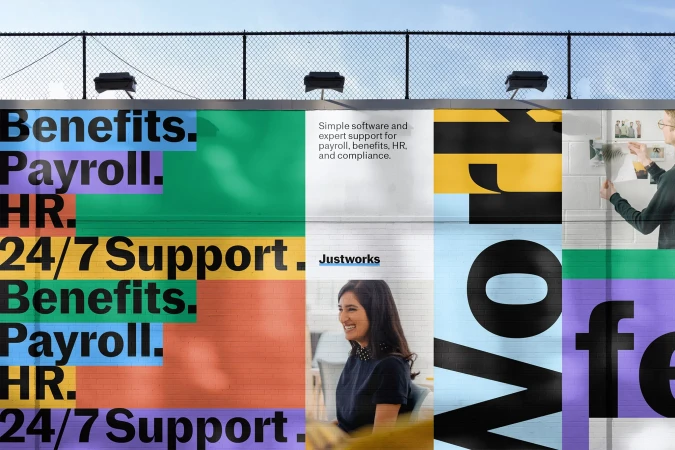 Outdoor billboard with colorful text blocks advertising business software, featuring smiling woman and person pinning photos.