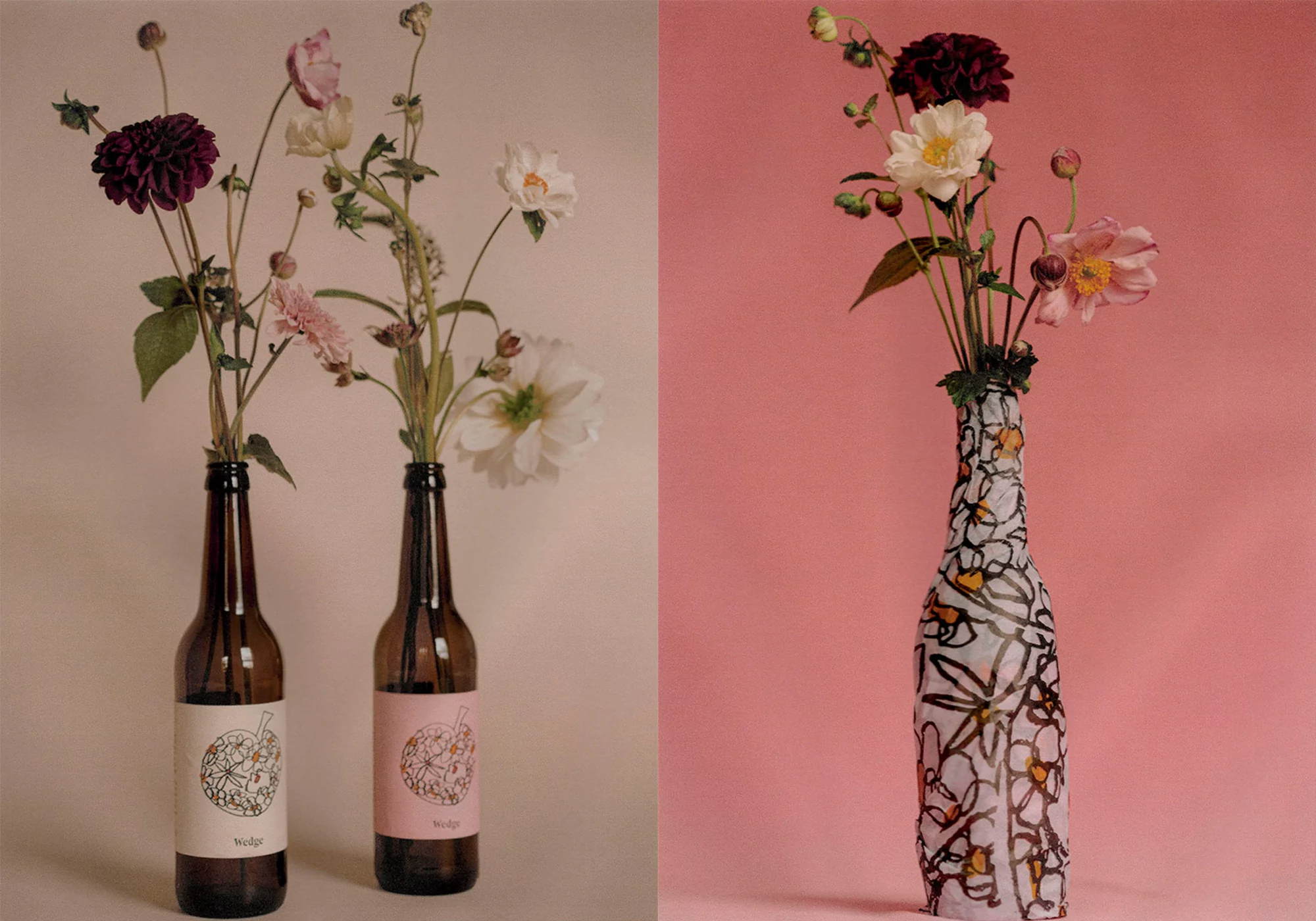 Floral still life featuring two brown glass beer bottles with pink and white labels, each holding a bouquet of colorful flowers.
