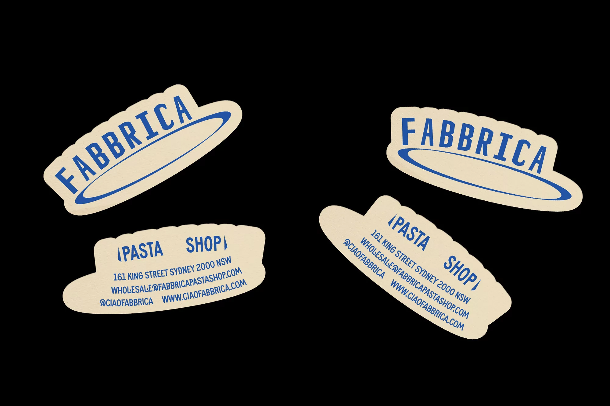 Four die-cut stickers featuring the word 'Fabbrica' and 'Pasta Shop' in blue lettering on a tan background, set against a black backdrop.