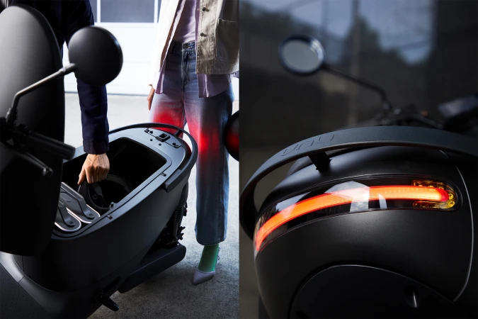 Person reaches into storage compartment on a black scooter, close-up of rear light detail of scooter, modern design, studio shot.