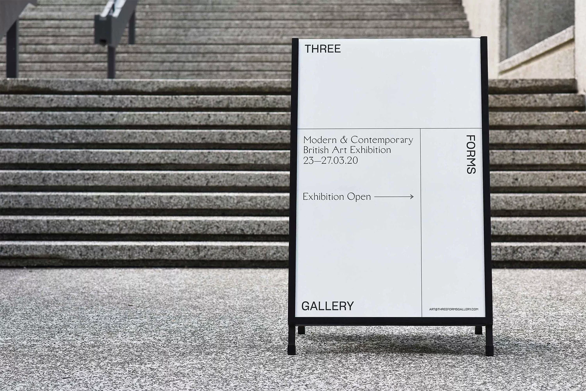Exhibition sign for 'Modern & Contemporary British Art Exhibition' outside a gallery, next to concrete stairs and textured concrete flooring.