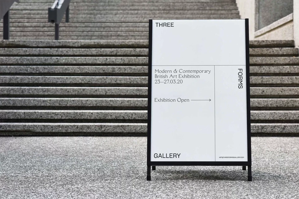 Exhibition sign for 'Modern & Contemporary British Art Exhibition' outside a gallery, next to concrete stairs and textured concrete flooring.