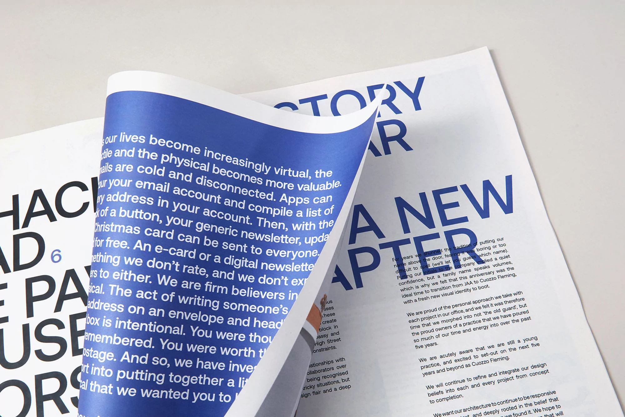 Close-up shot of two white pages with blue printed text. One page is turned over, revealing text about a new chapter and family.