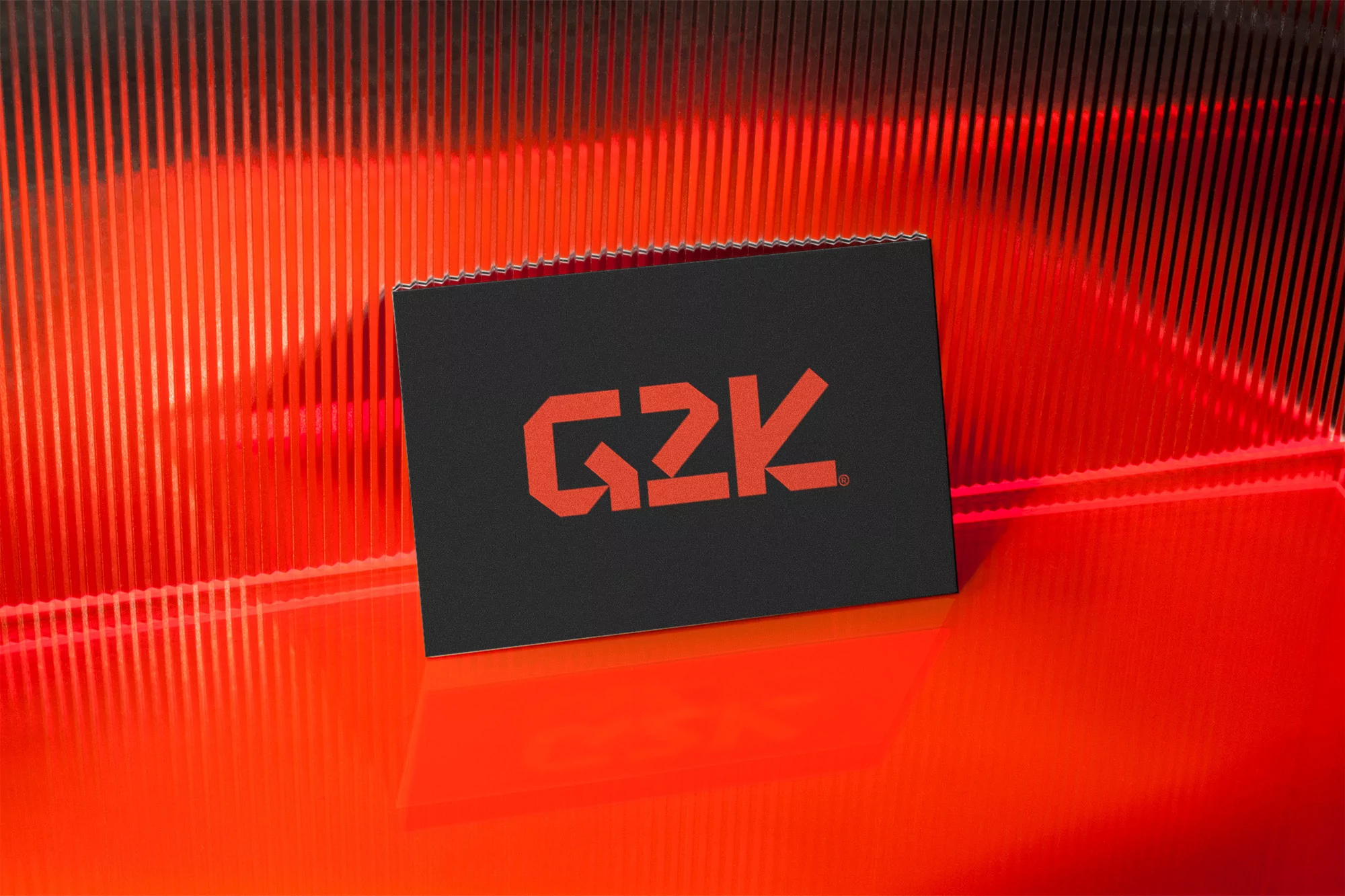 Black rectangular package with red 'G2K' logo against a modern red-lit linear background on a glossy surface, product photography.