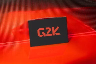 Black card featuring the red G2K brand logo positioned on a glossy red reflective surface against a ribbed red panel background.