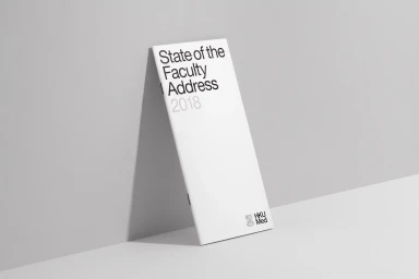 White booklet titled State of the Faculty Address 2018 leaning against a pale grey studio wall designed by Toby Ng Design for HKUMed