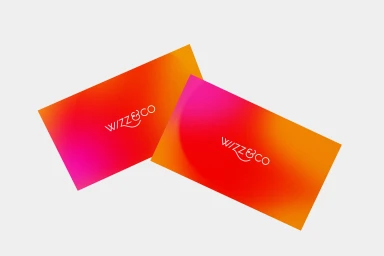 Two business cards with vibrant gradient color fields and white typography resting against a neutral background