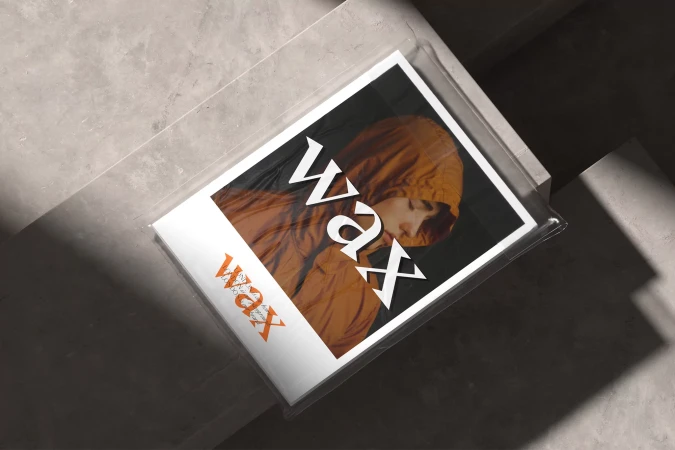 Fashion magazine cover features person in hooded jacket; set on grey concrete background with shadows. Modern studio photography.