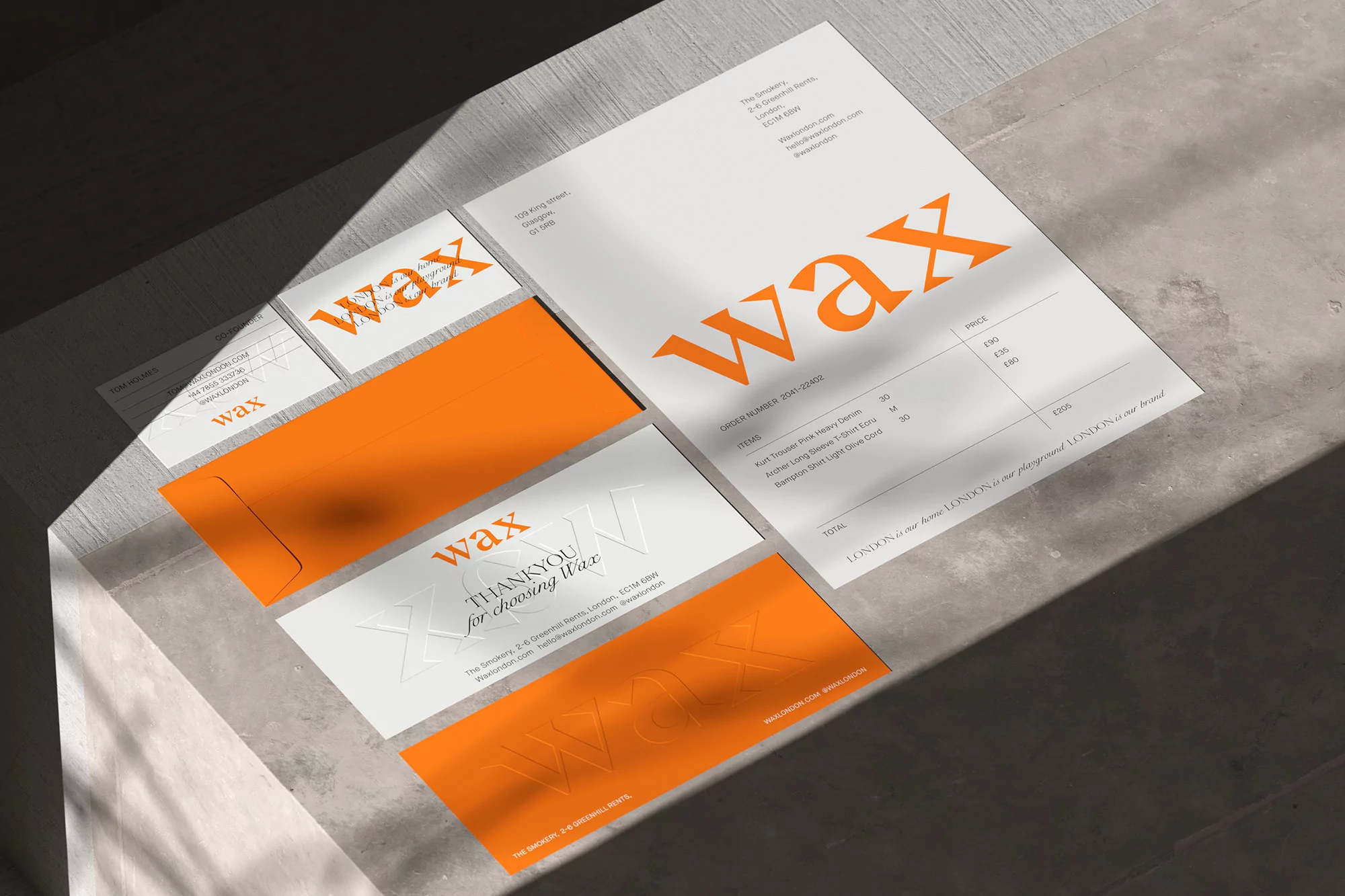 Promotional layout of matching 'Wax' branded business stationery featuring invoice, envelope, business cards and thank you cards on a gray surface.