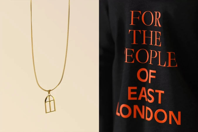 Gold chain necklace with architectural pendant; black sweatshirt with orange text 'For The People of East London'.