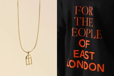 Gold chain necklace with arched window pendant alongside a black shirt featuring red typographic text.