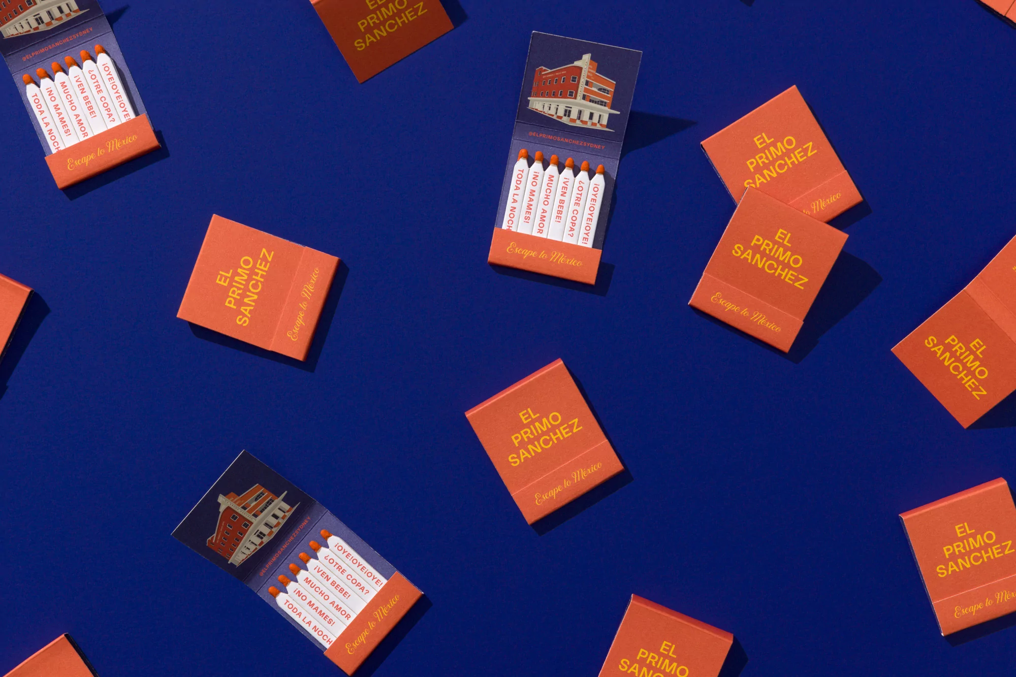 Overhead shot of orange matchboxes on blue backdrop featuring the El Primo Sanchez logo and a graphic of a building.