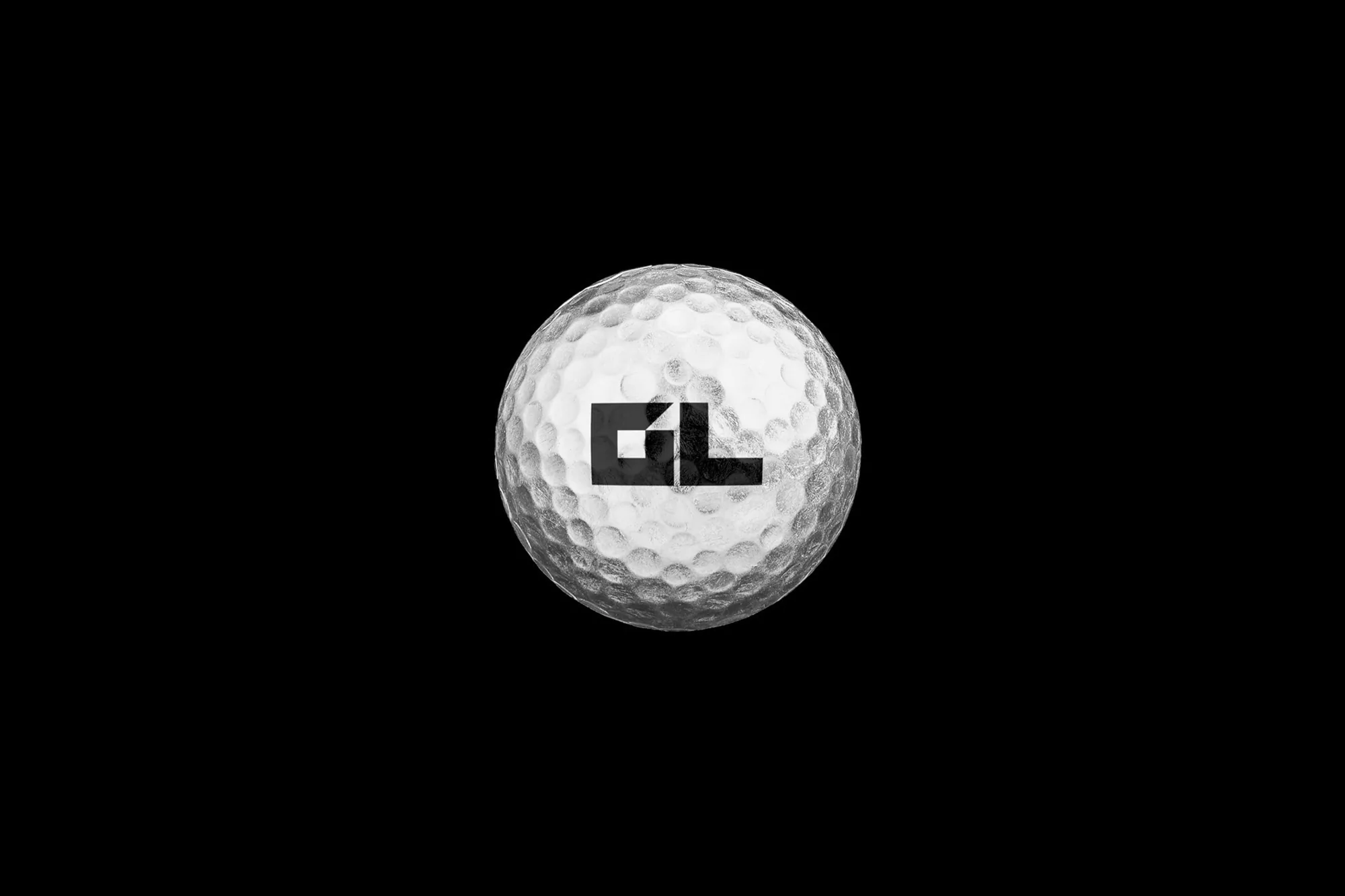 Golf ball against a black background with the letters GL in a dark font on the surface.