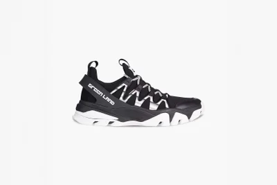 Black and white sneaker with distinctive zig-zag side strap and bold white sole against a plain white background