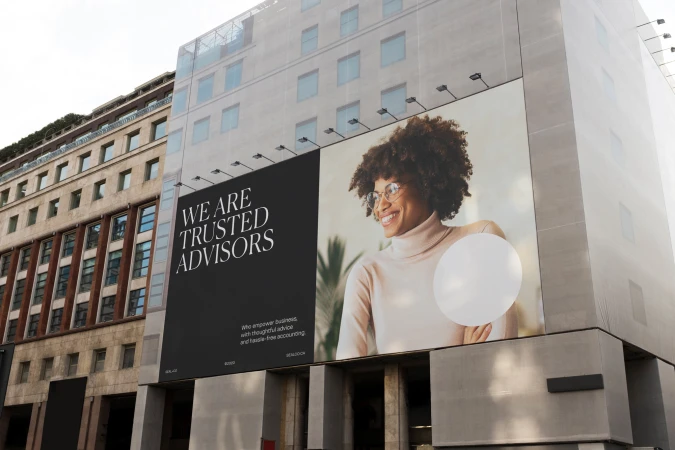 Outdoor billboard features an Afro-Caribbean woman in a commercial advertisement for financial advisors set against an urban building facade.