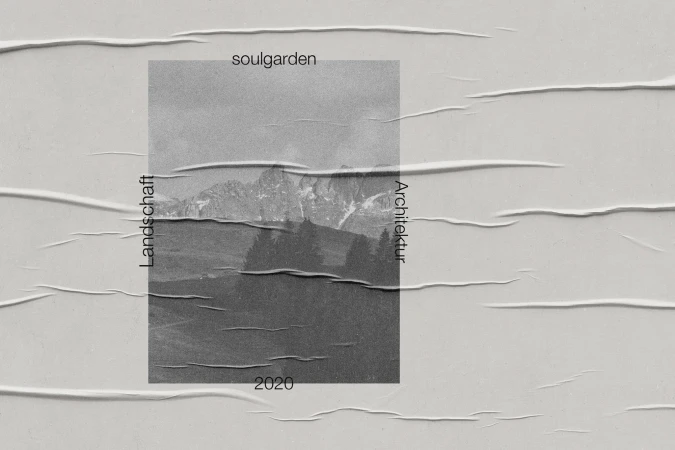 Poster featuring a monochrome landscape with mountains, trees, and text, adhered to a textured gray surface with creased edges.