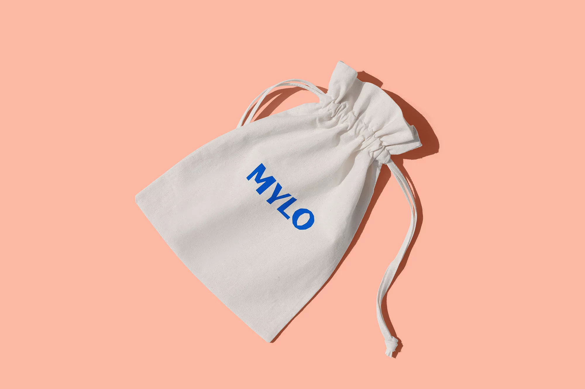 White drawstring bag with the text 'MYLO' in blue on a peach background, product shot, showcasing minimalist branding and design.