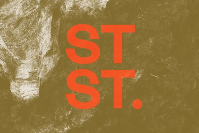 Text graphic on a brown and white textured background, featuring large orange letters 'ST.' stacked twice vertically.