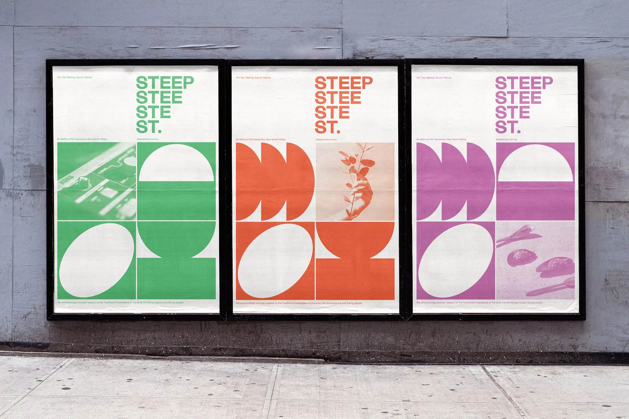 Three colorful art posters with geometric designs in a black frame are displayed on a grey urban wall, viewed in daylight.