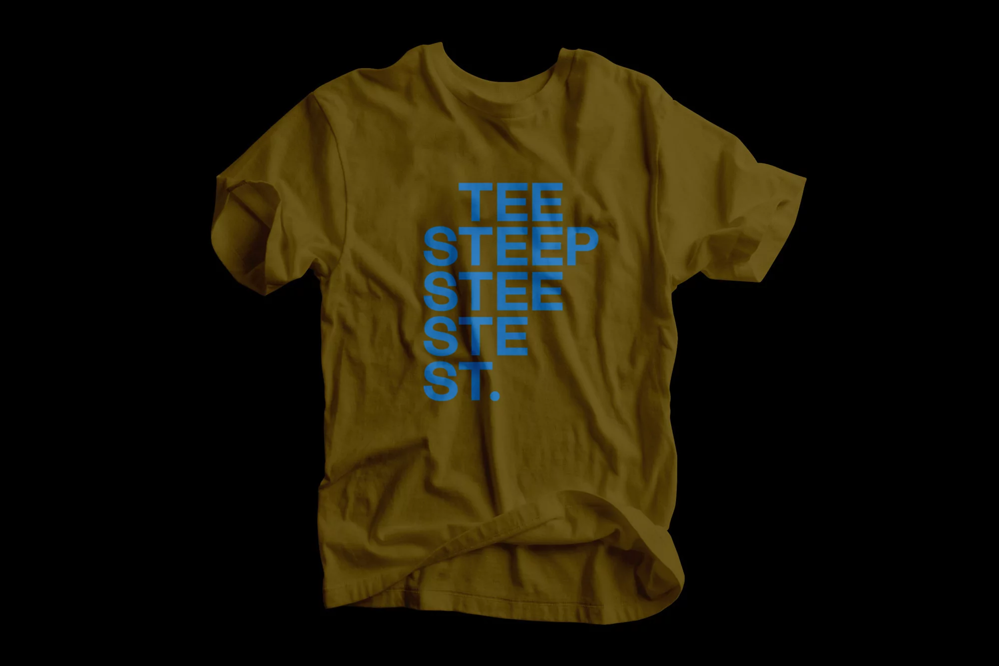 Mustard t-shirt with a blue inscription 'TEE STEEP STEE ST ST.' in a studio shot set against a black backdrop, fashion apparel.
