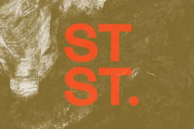 Orange ST. typography overlaid on a textured earth-toned background showing rocky details.