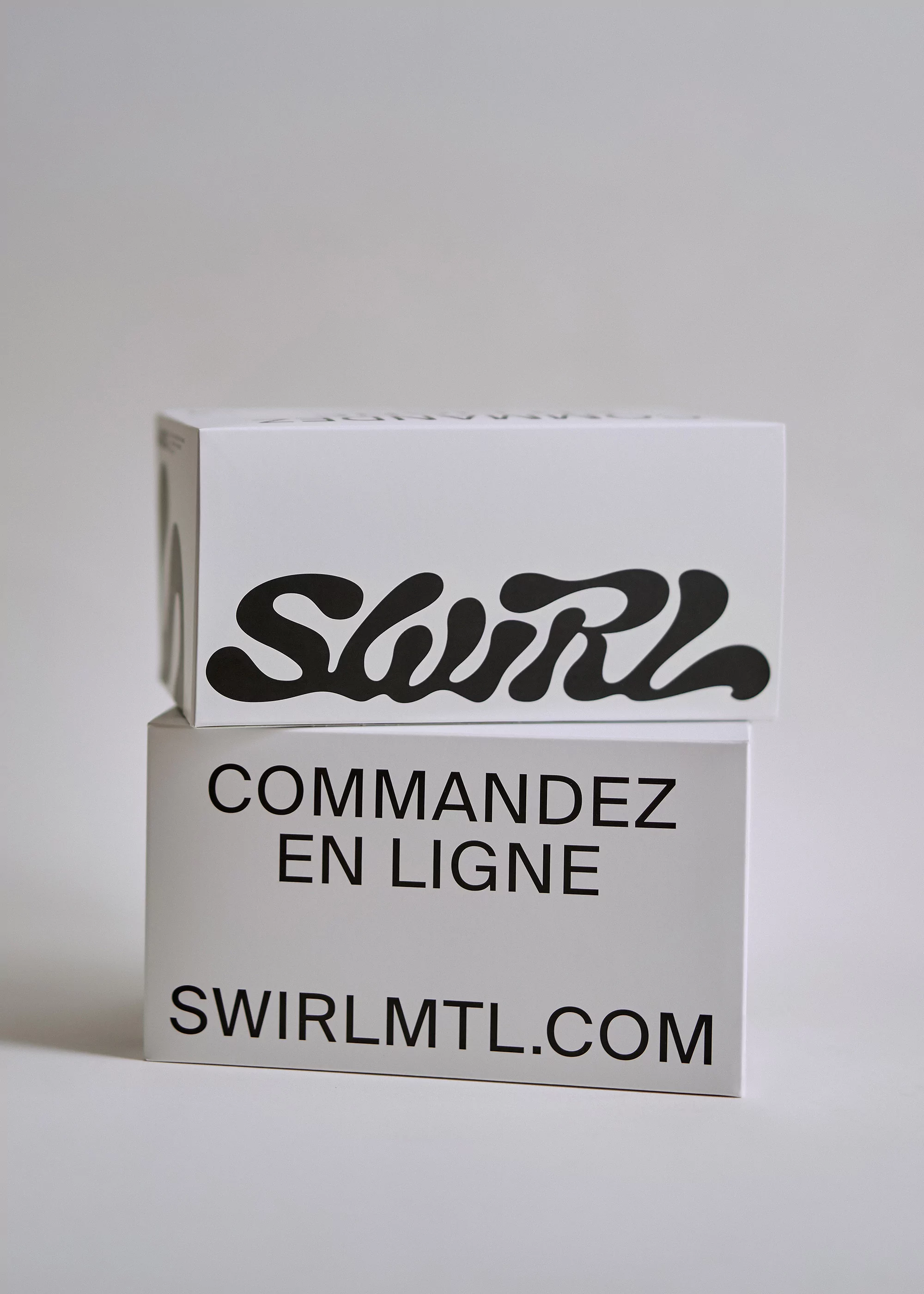 Two rectangular boxes stacked, the top one with 'SWIRL' in large black letters, the lower one with website address in black font.