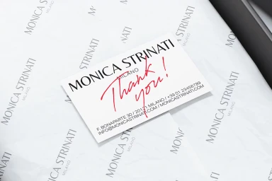 Close-up of a branded thank you card resting on top of custom tissue paper featuring printed typography.