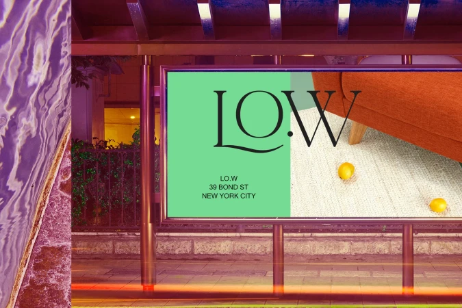 Outdoor advertising billboard displays a furniture advertisement featuring a modern orange sofa, lemons, and the brand name L.O.W.