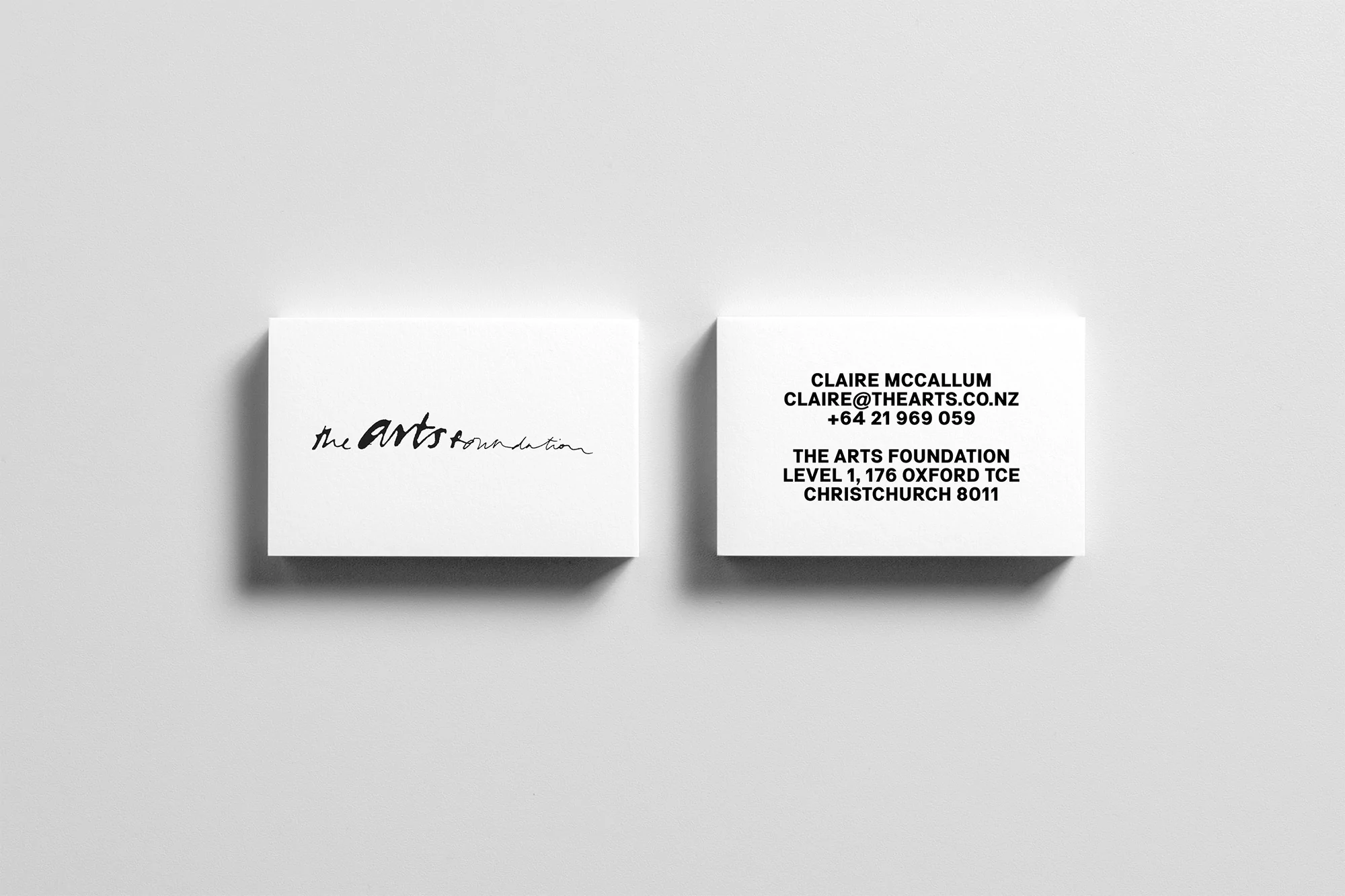 Two business cards featuring 'The Arts Foundation' branding, with contact information for Claire McCallum on a light gray surface.