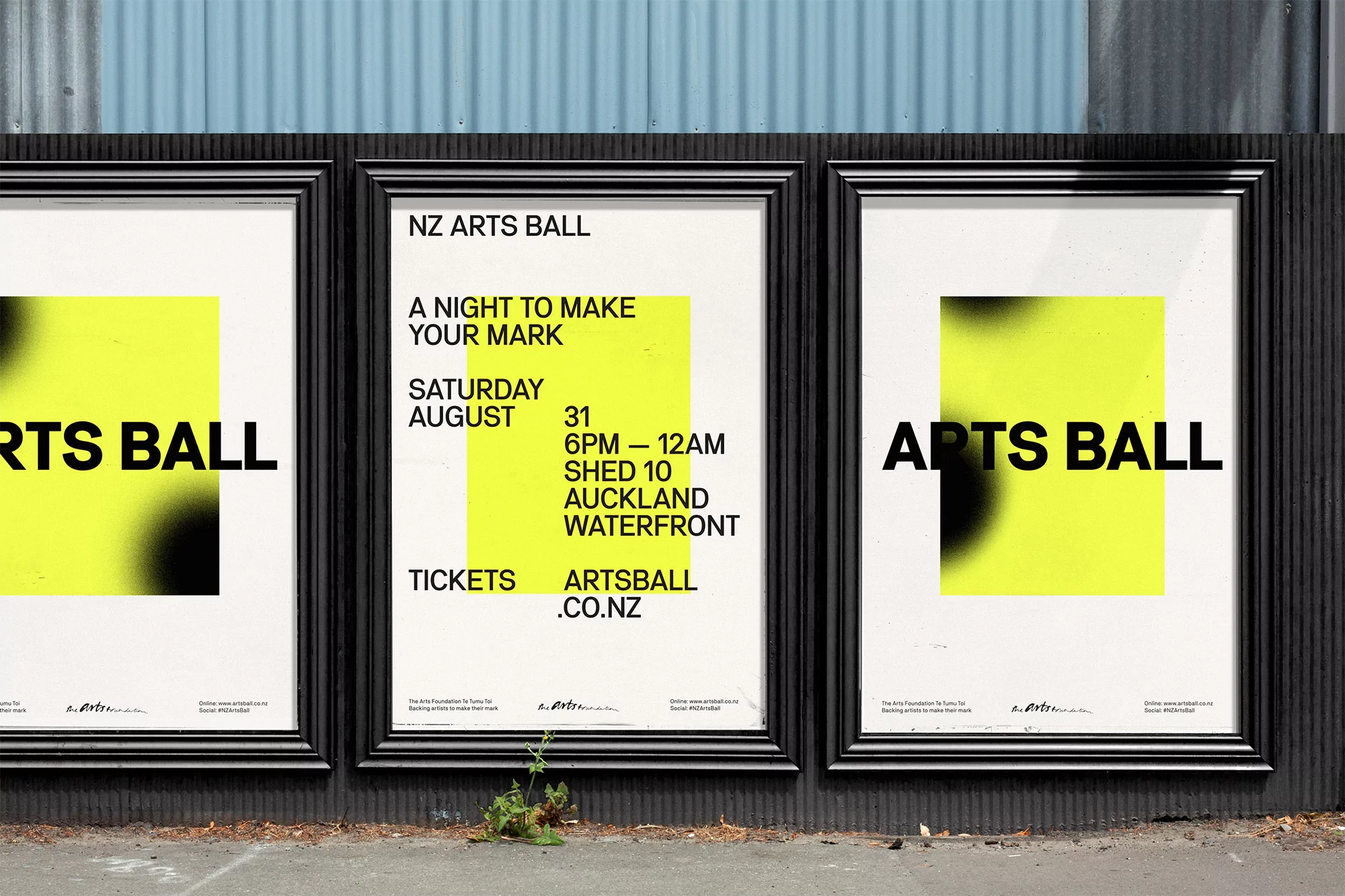 Three posters for the NZ Arts Ball feature a yellow square with a black gradient and bold text on a textured gray wall outdoors.
