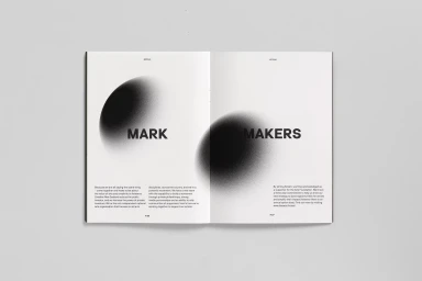Open magazine spread displaying minimalist black typography and grainy abstract circular graphics on white pages.