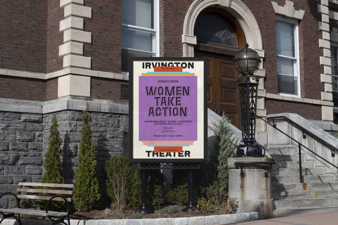 Outdoor view of a 'Women Take Action' event advertisement poster, in front of a brick theater building and stone steps on a sunny day.