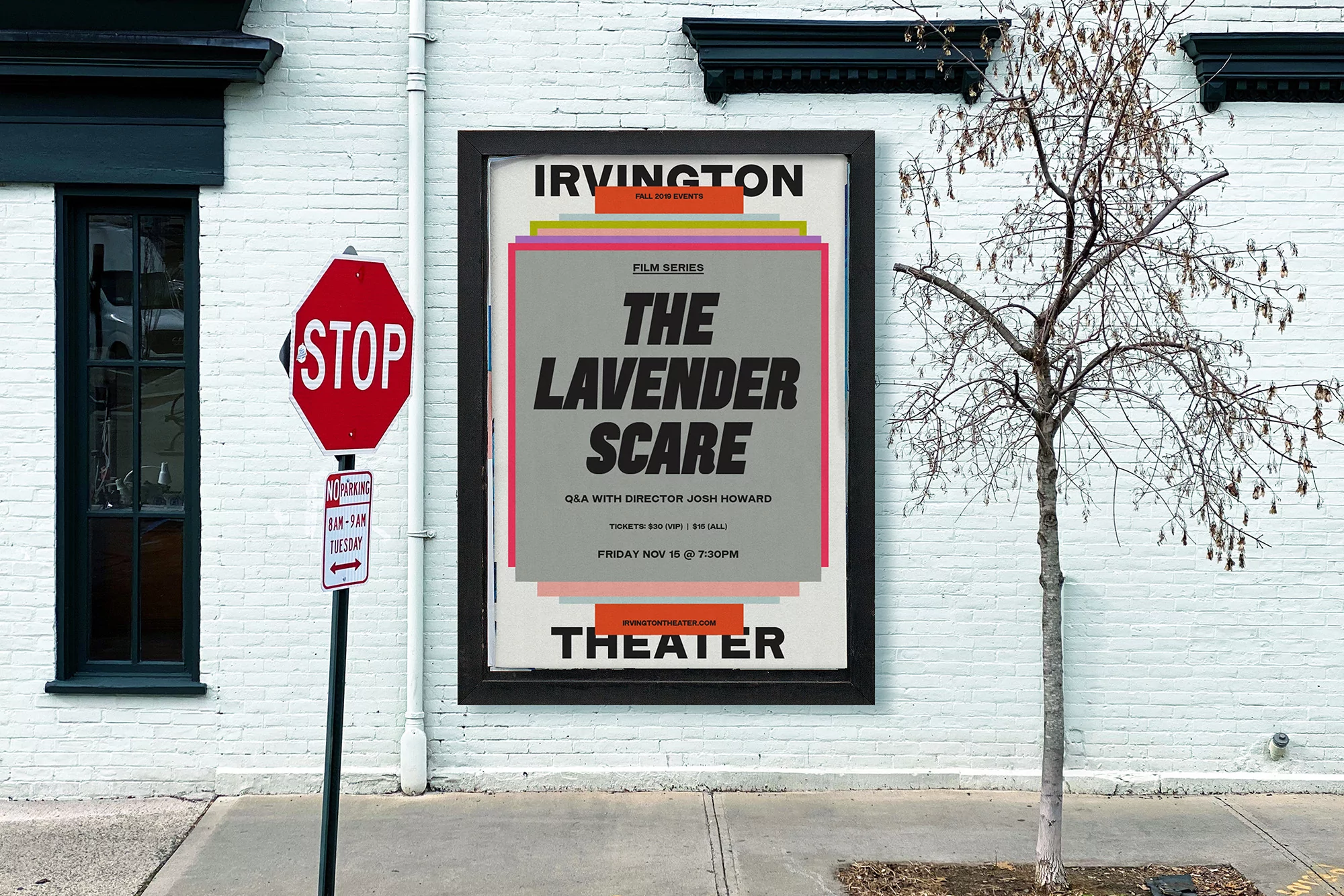 Outdoor shot of a vintage movie poster for The Lavender Scare, mounted on a white brick wall with a stop sign and leafless tree.
