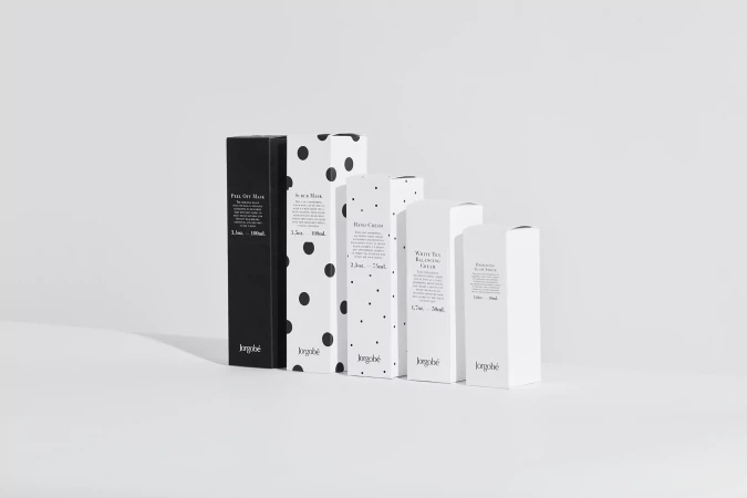 Product packaging in minimalist black, white and polka dot design, featuring Jorgobé branded skin care creams and masks.