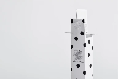 Polka dot packaging box for Jorgobe scrub mask standing against a plain white background