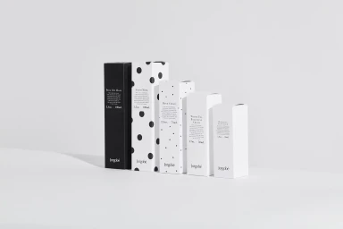Five minimalist black and white skincare boxes arranged in a row on a plain white studio backdrop.