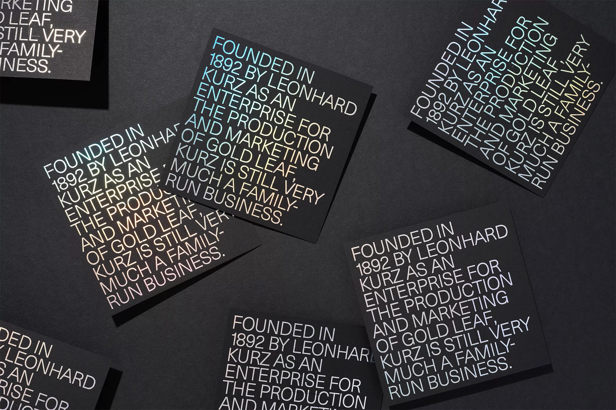 Several black square cards with white text laid out on a black surface, creating a minimalist, high-contrast graphic design.