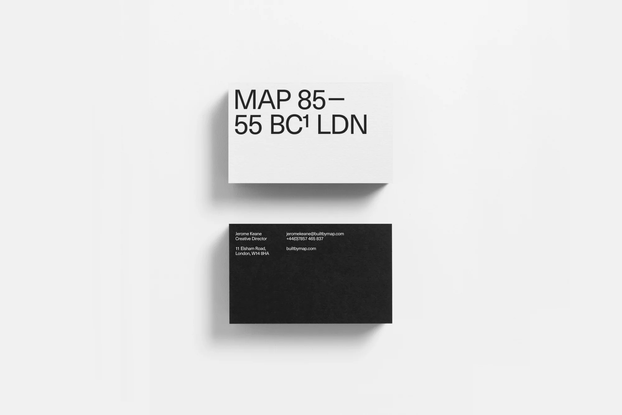 Two business cards, one white with 'MAP 85-55 BC1 LDN' and one black with 'Jerone Keane Creative Director'. Minimal design against white.