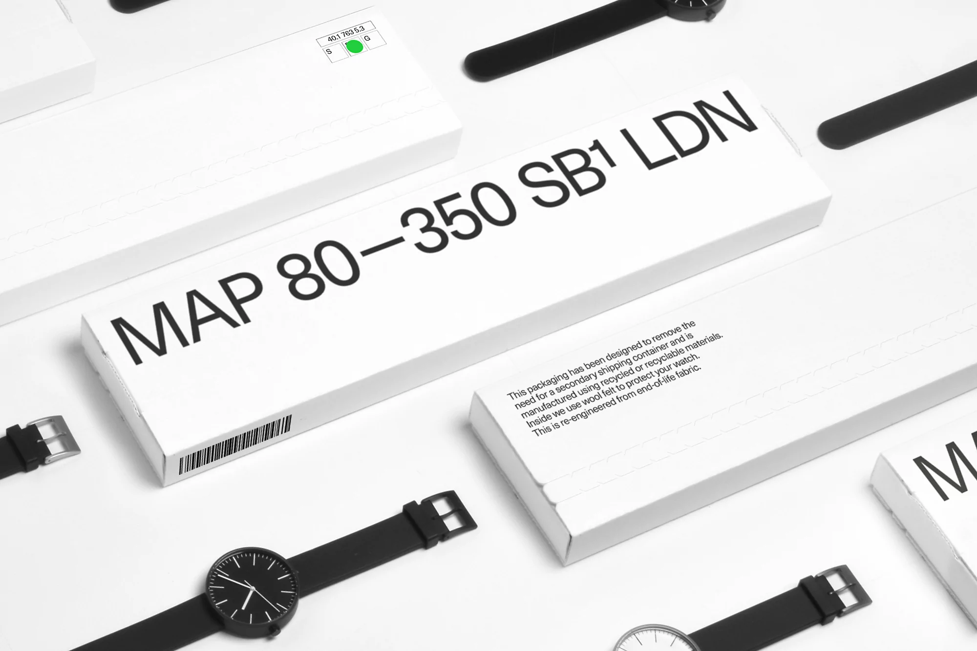 Wristwatches in minimalist black-and-white aesthetic, displayed on white surface with watch packaging, emphasizing clean design and style.