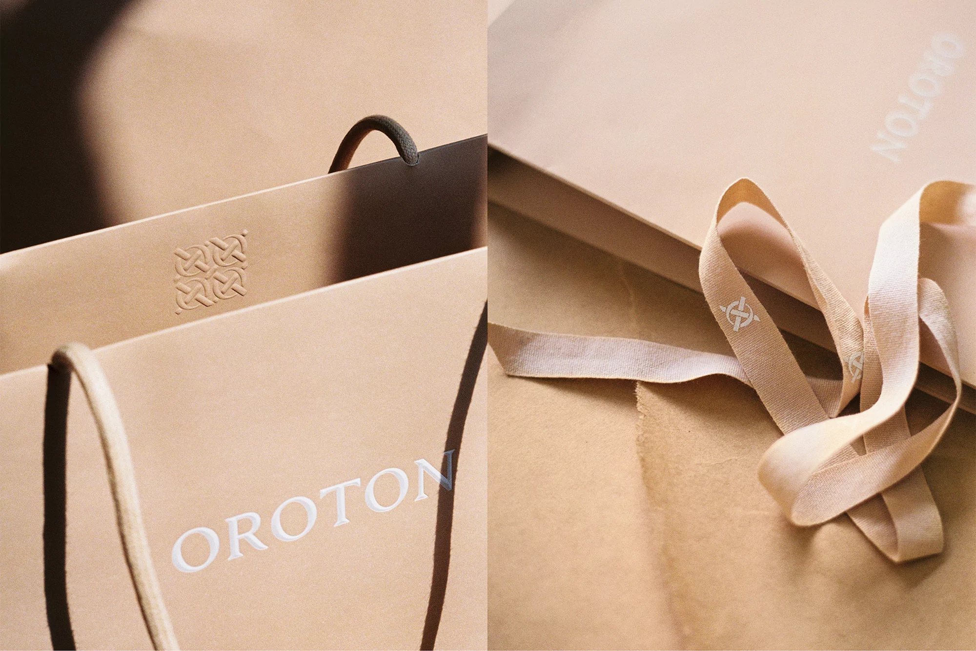 Close-up of two tan-colored shopping bags with 'OROTON' logo and ribbon detail, set against a neutral backdrop, emphasizing luxury retail.